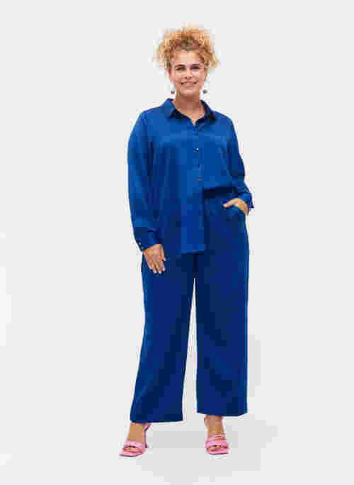 Loose fitting trousers with light shine and width