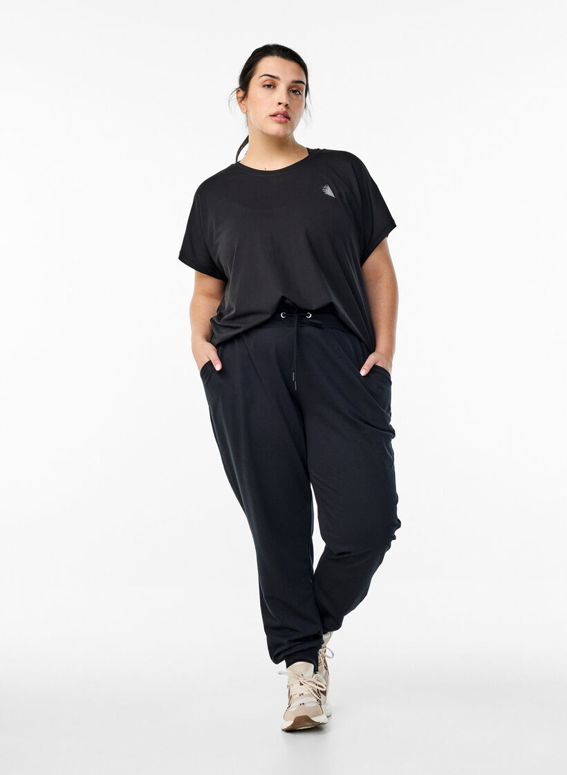 Loose tracksuit trousers with pockets, Black, Model image number 1
